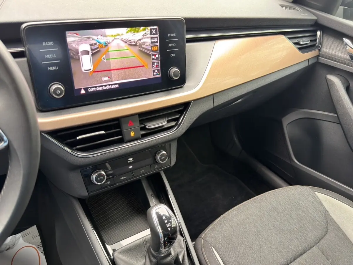 Vue intérieure du tableau de bord et console centrale du Skoda Kamiq 2023 avec écran tactile affichant la caméra de recul.