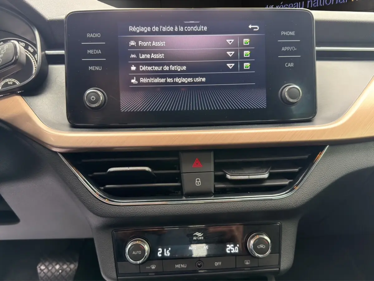 Écran tactile central affichant les aides à la conduite dans l’habitacle du Skoda Kamiq gris foncé.