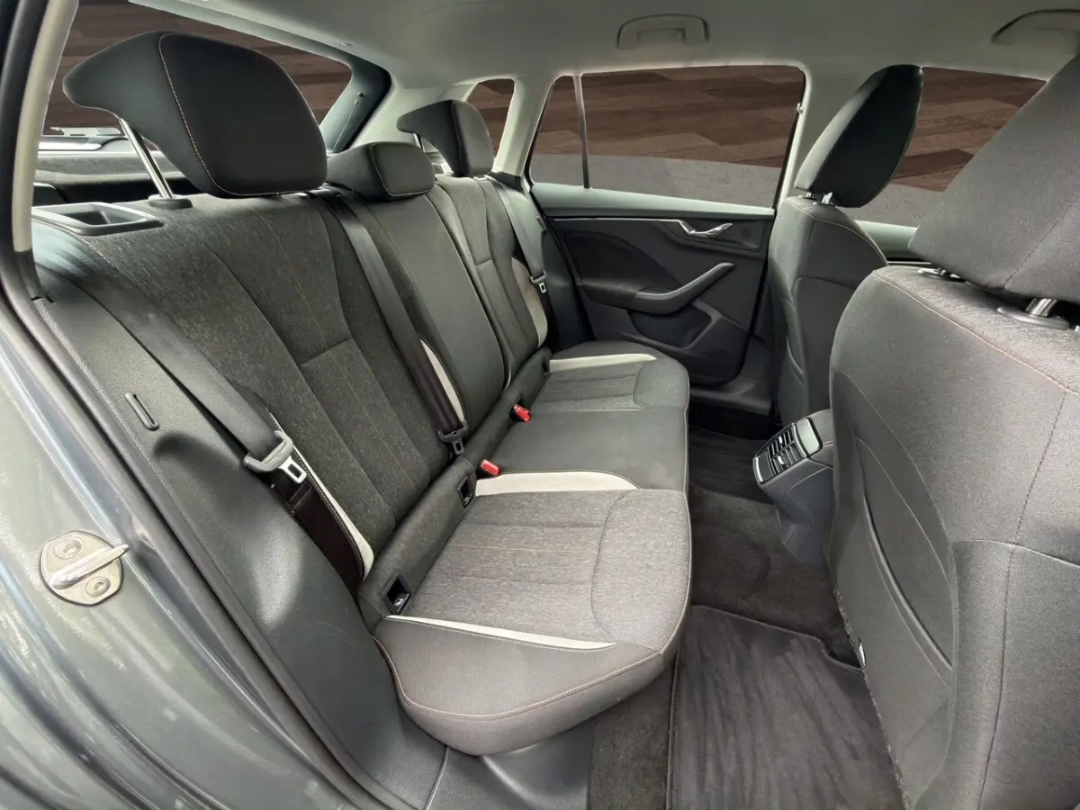 Vue intérieure arrière côté gauche du Skoda Kamiq gris foncé, sièges tissu bi-ton avec surpiqûres orange.