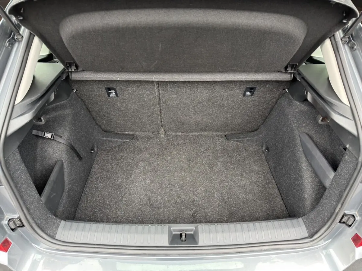 Vue intérieure du coffre ouvert d’un Skoda Kamiq gris foncé, montrant un espace de rangement propre et tapissé.