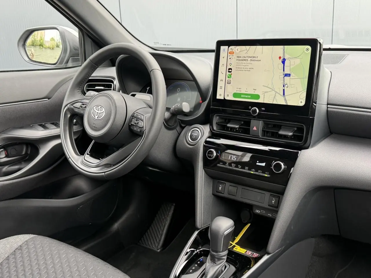Vue intérieure côté conducteur de la Toyota Yaris Cross 1.5 Hybrid 116 Design avec écran tactile et volant cuir noir.