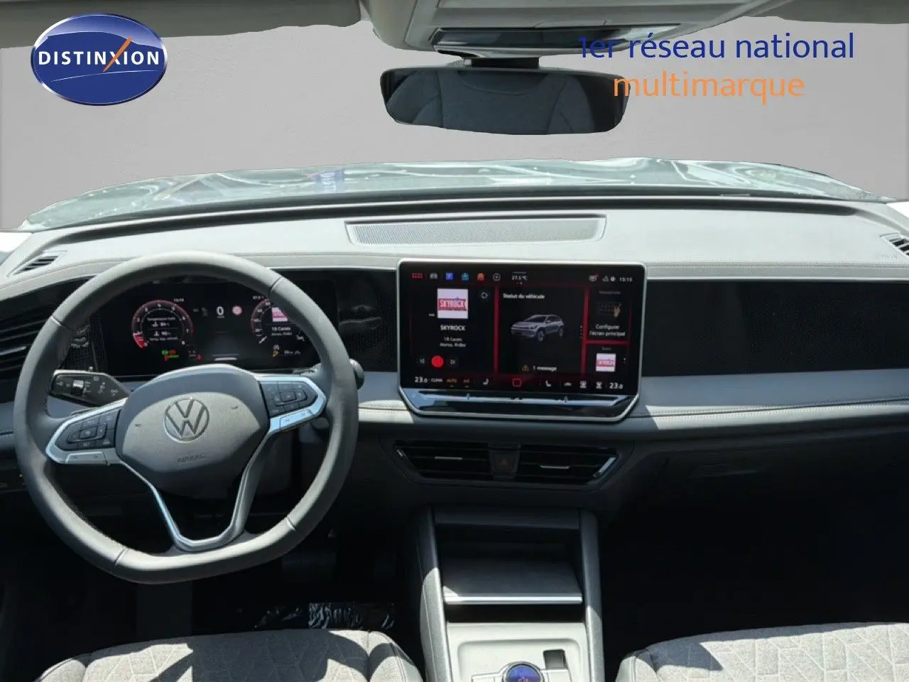 Vue frontale intérieure du Volkswagen Tiguan gris dauphin, tableau de bord moderne avec écran tactile central et volant multifonction.