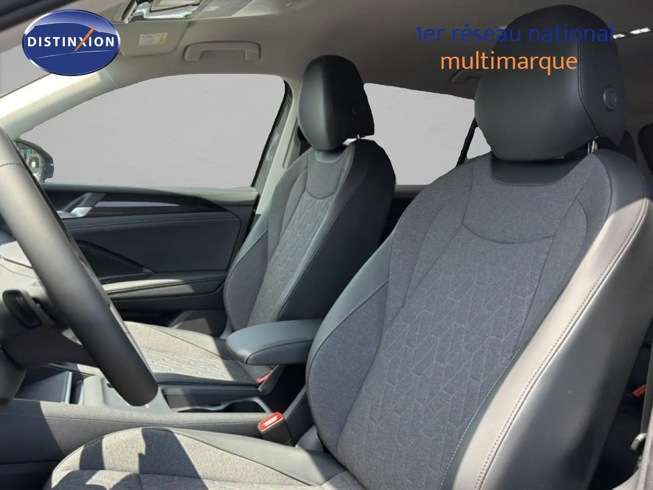 Vue intérieure du Volkswagen Tiguan 2026, sièges avant en tissu gris et cuir noir avec détails modernes.