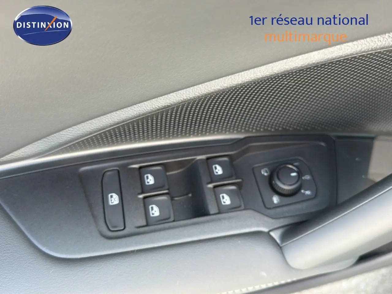 Gros plan sur les commandes des vitres et rétroviseurs côté conducteur d’un Volkswagen Tiguan gris dauphin métal.