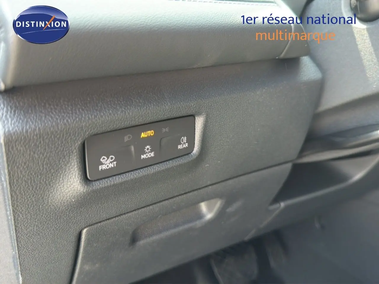 Détail du tableau de bord noir du Volkswagen Tiguan 2026 avec commandes d’éclairage automatiques visibles.