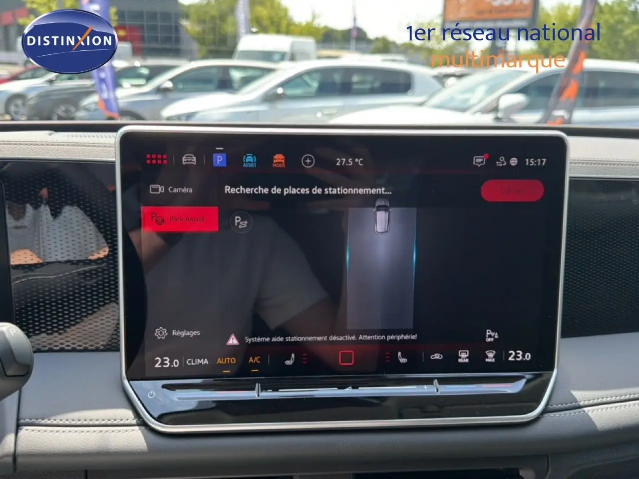 Vue intérieure centrée sur l'écran tactile du Volkswagen Tiguan gris dauphin, affichant l'assistance au stationnement.