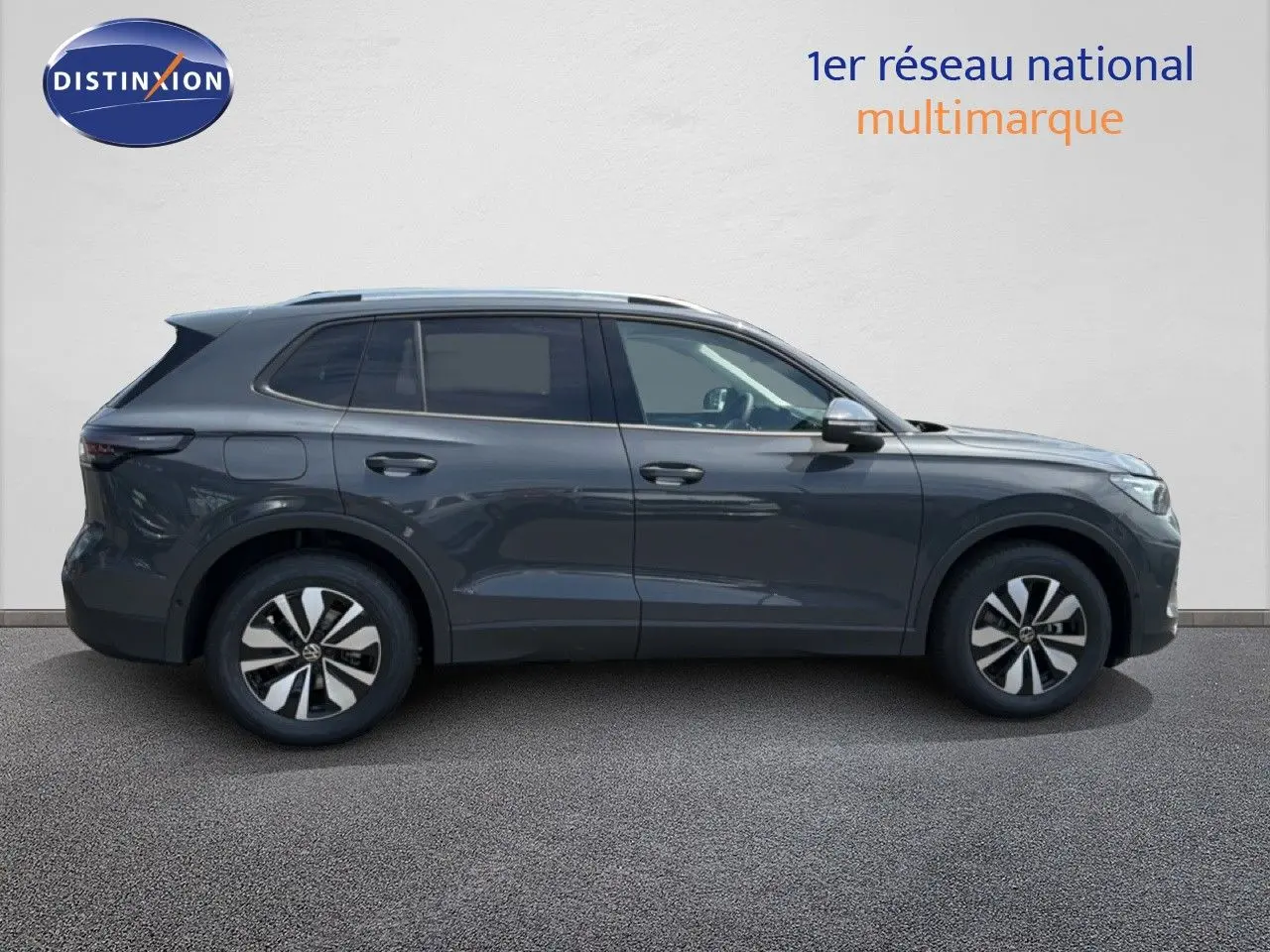 Profil droit d’un Volkswagen Tiguan gris dauphin métallisé 2026 avec jantes bi-ton et toit ouvrant.