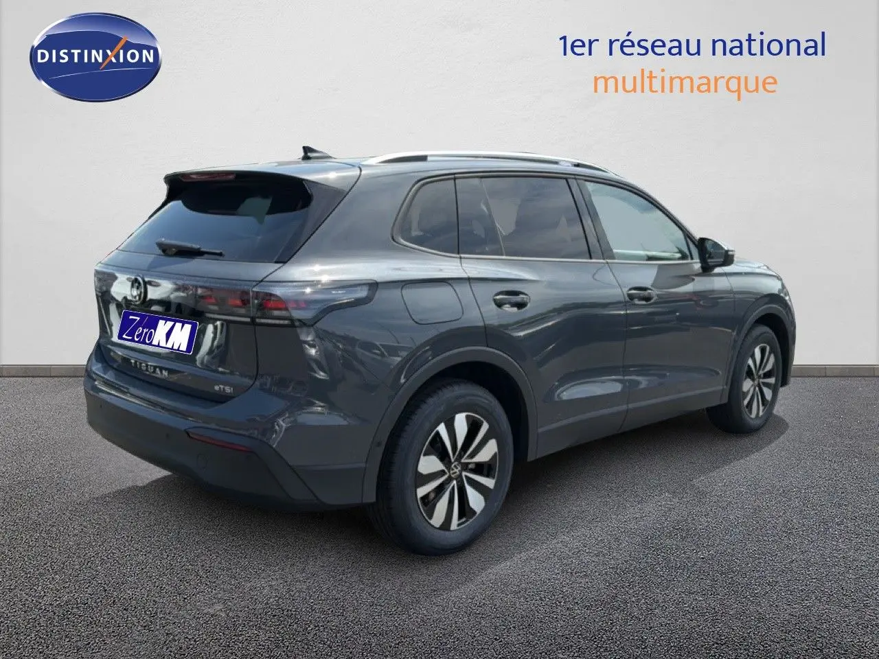 Volkswagen Tiguan gris dauphin métal vu en 3/4 arrière droit avec jantes alliage et vitres teintées.