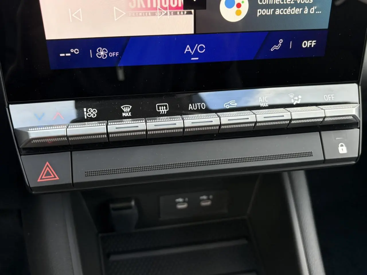 Gros plan sur la console centrale noire du Renault Symbioz 2025, avec commandes climatisation et écran tactile visible.