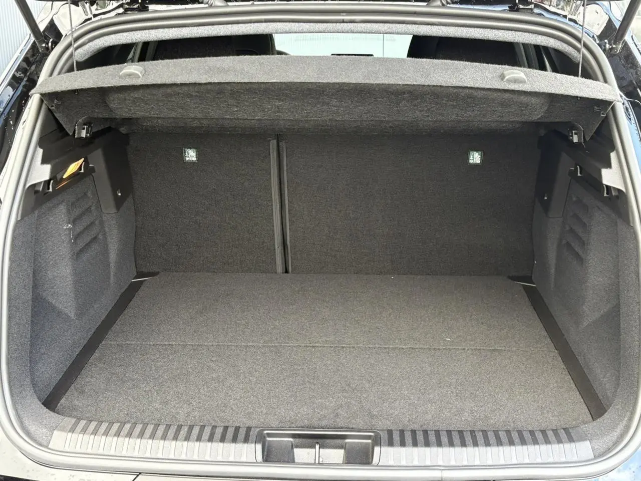 Coffre ouvert du Renault Symbioz noir étoile, vue intérieure montrant l'espace de rangement vide et la moquette grise.