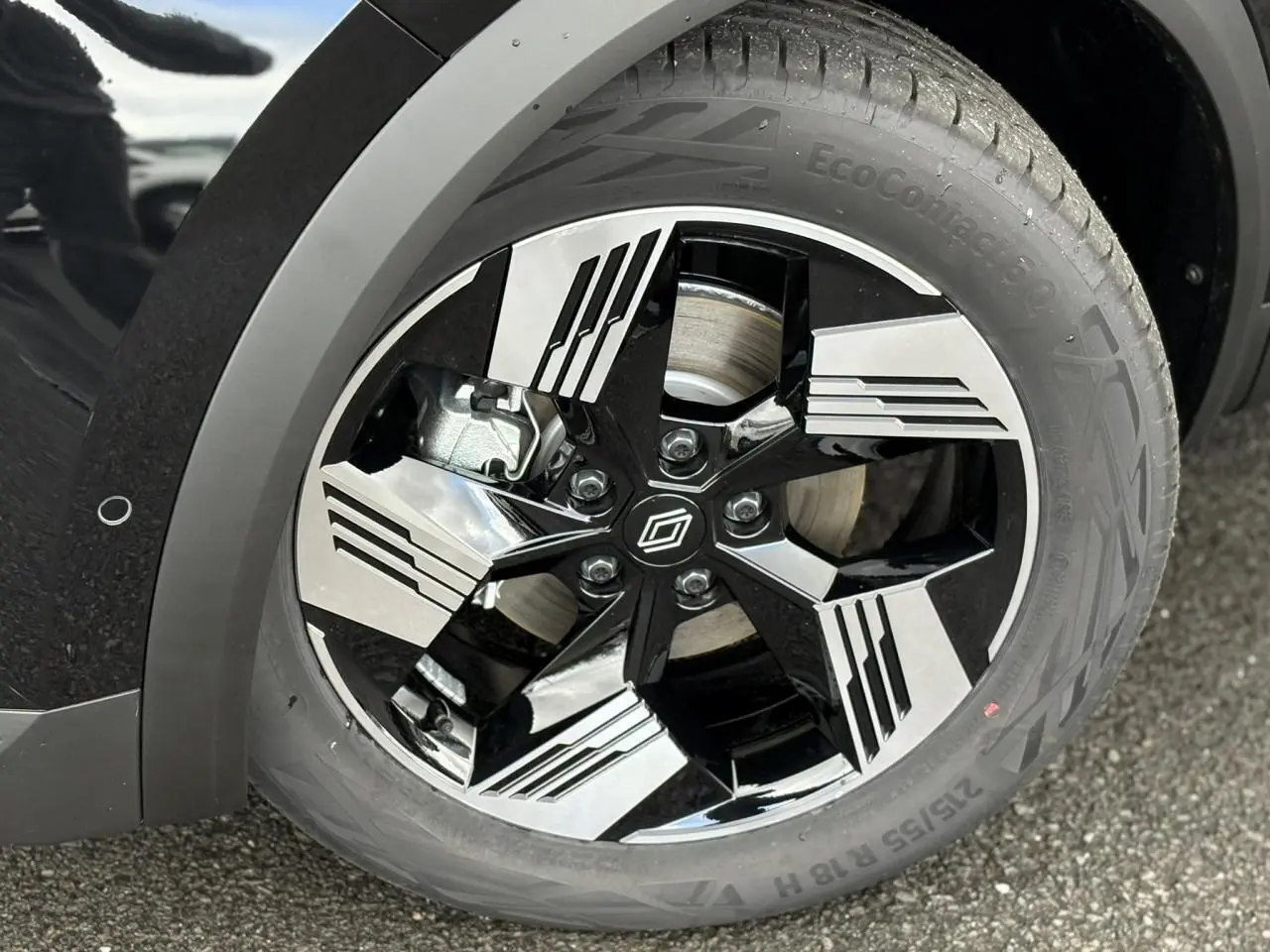 Gros plan sur la jante 18 pouces bicolore noire et argent du Renault Symbioz noir étoile, avec logo central distinctif.