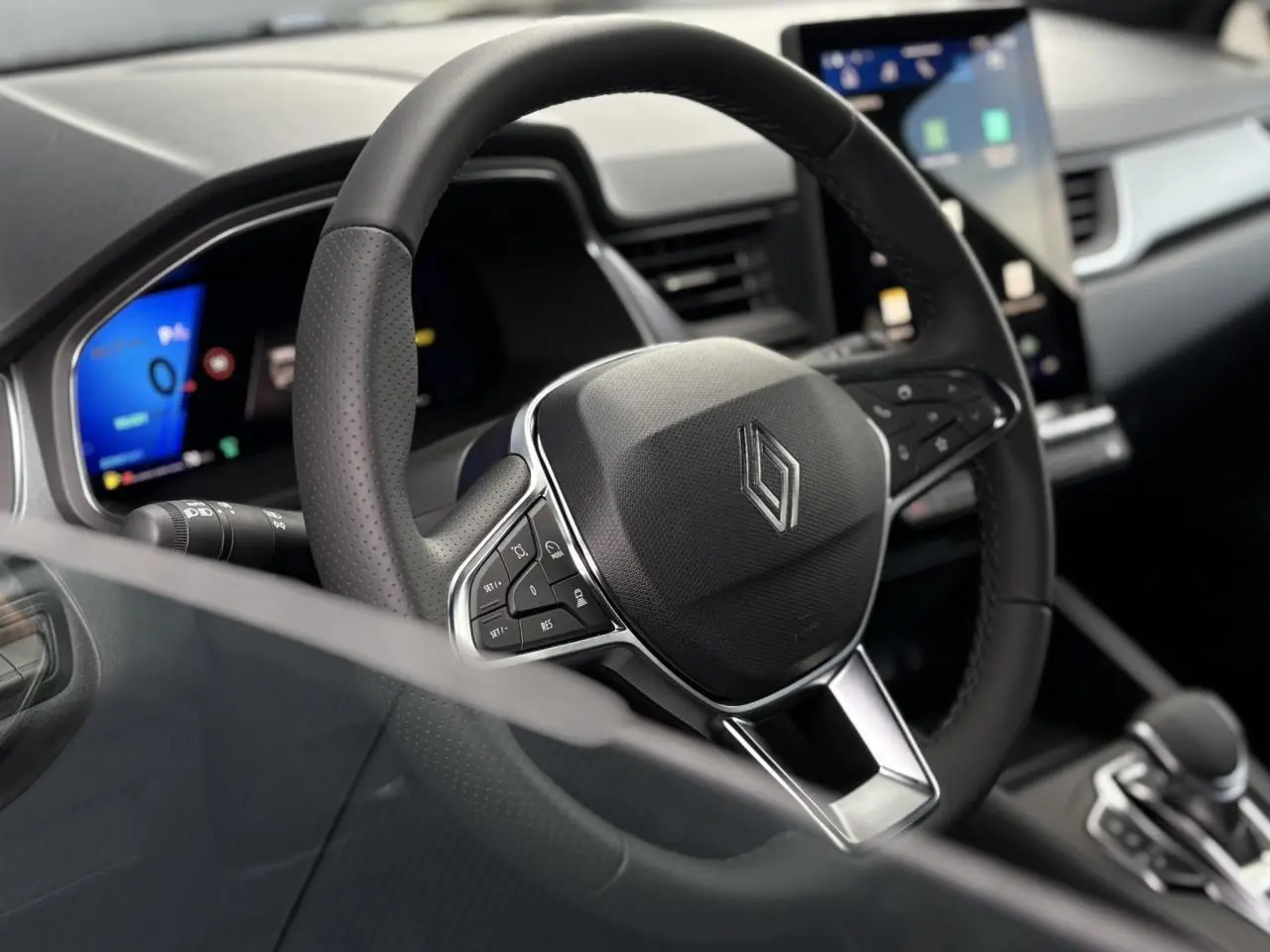 Gros plan sur le volant en cuir noir et le tableau de bord numérique du Renault Symbioz E-Tech 2025.
