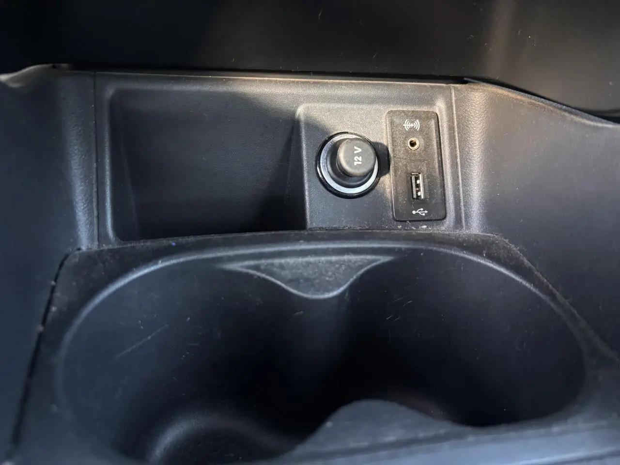 Prise 12V, port USB et prise jack dans le rangement central noir d'une SEAT Ibiza 1.2 TSI Style 2016.