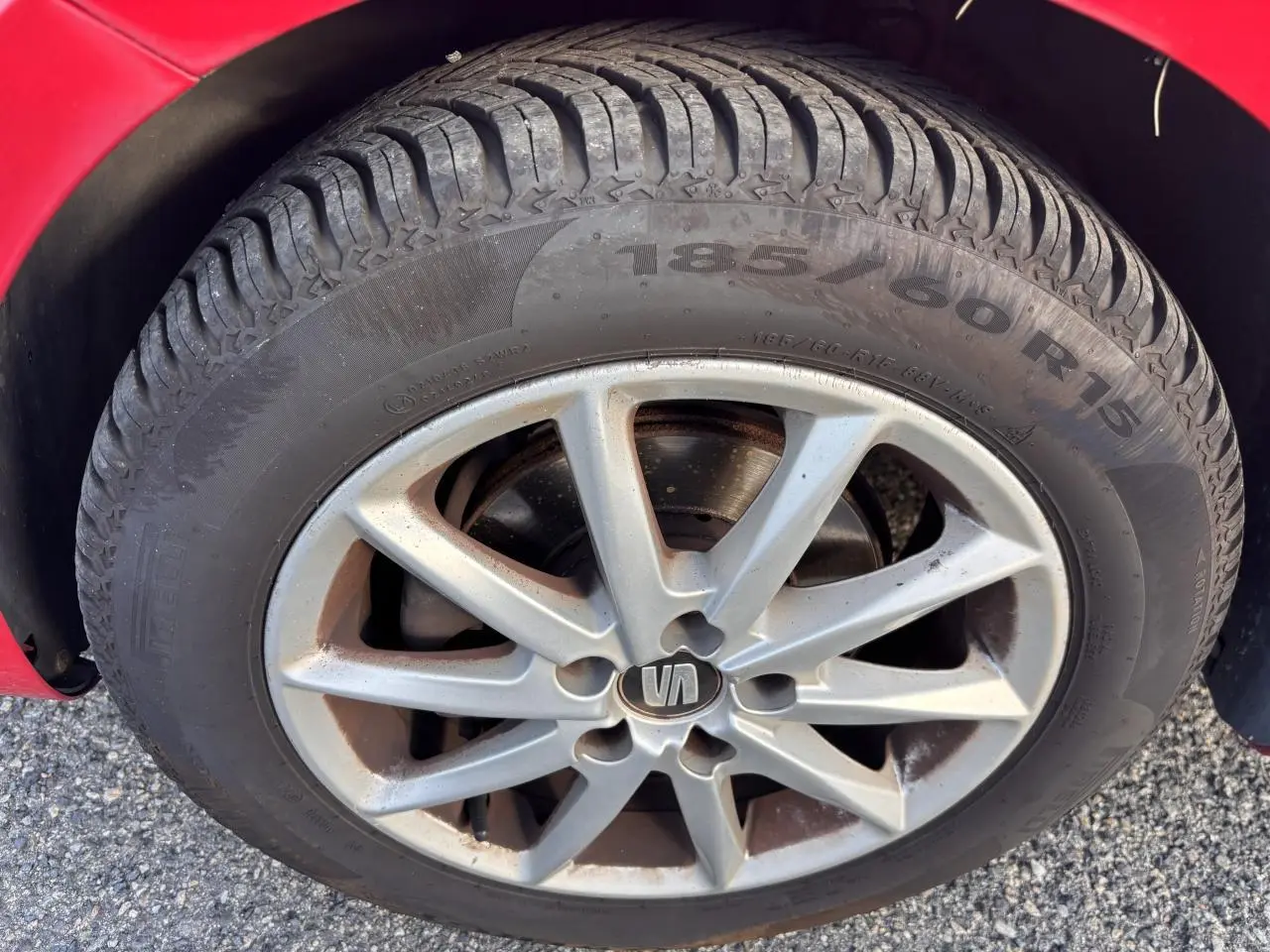 Gros plan sur la roue avant droite d'une SEAT Ibiza rouge clair de 2016 avec jante alliage à 10 branches.