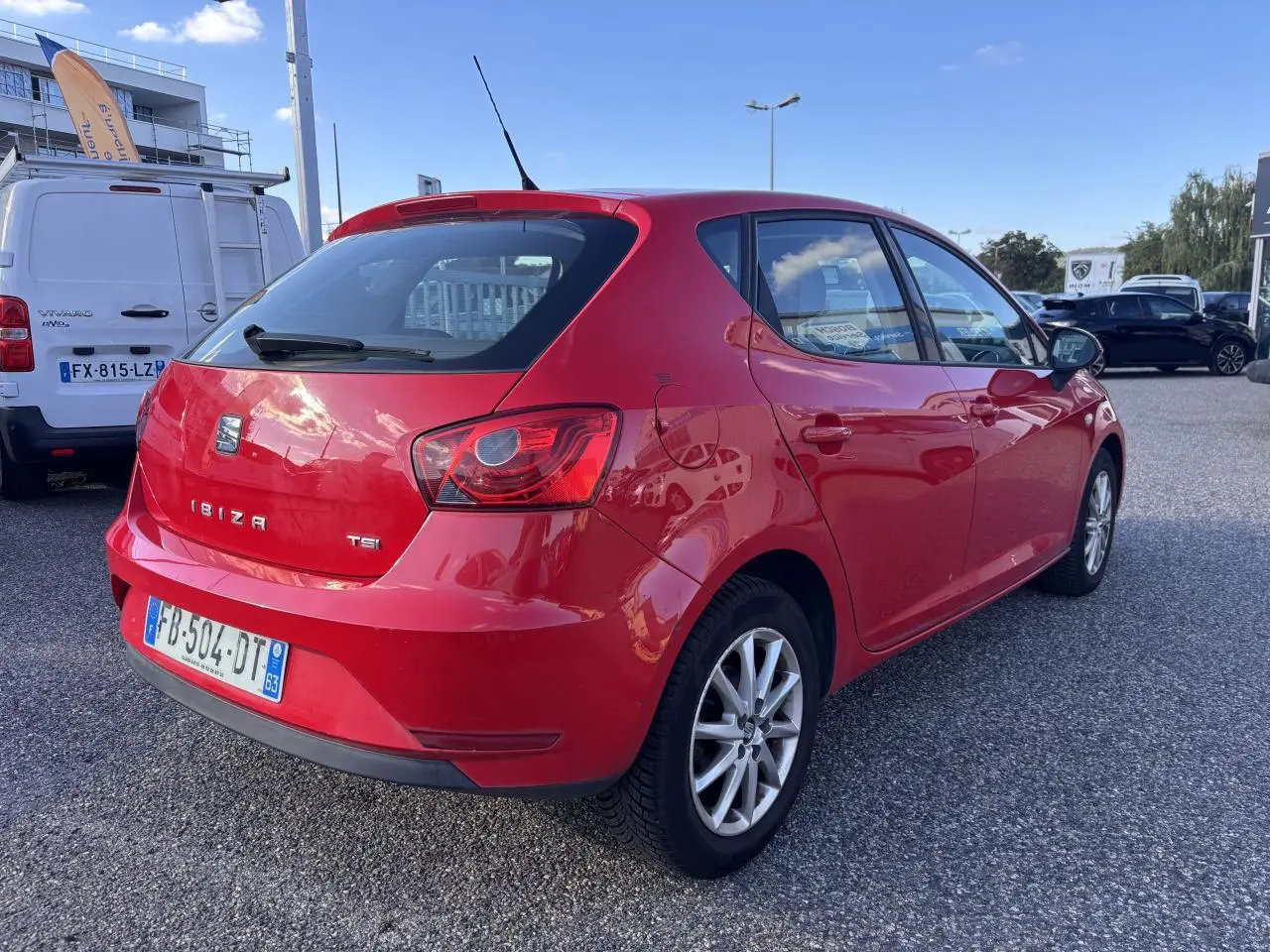 SEAT Ibiza 1.2 TSI Style rouge clair vue 3/4 arrière droit sur parking en extérieur, année 2016.