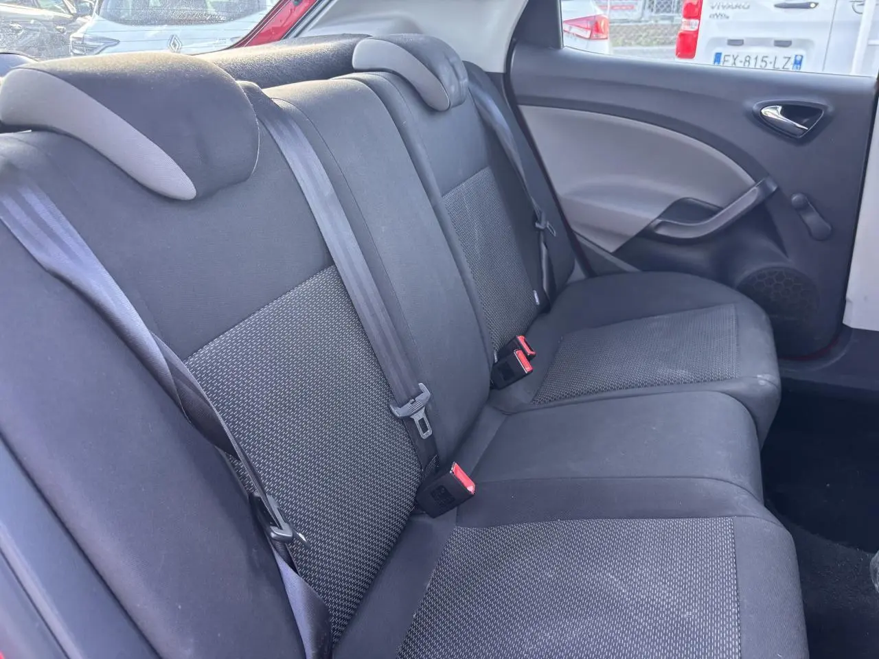 Banquette arrière en tissu gris foncé vue côté droit dans une SEAT Ibiza rouge clair de 2016.