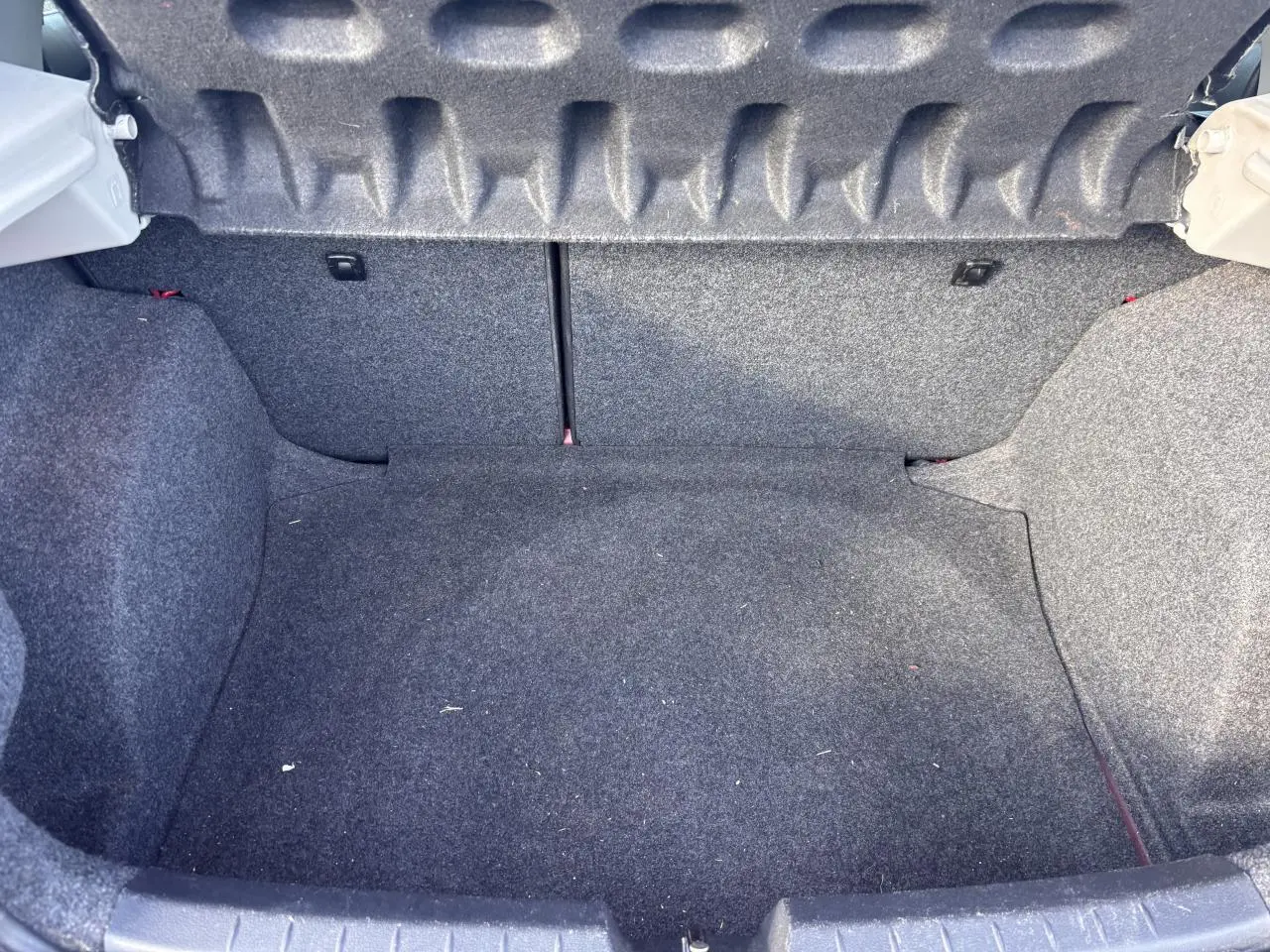 Coffre vide de la SEAT Ibiza 1.2 TSI Style 2016, vue intérieure arrière avec revêtement gris foncé.