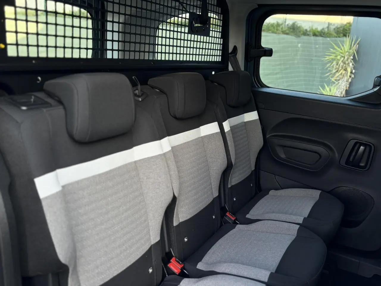 Vue intérieure côté droit sur les trois sièges arrière gris et noirs du Citroën Berlingo Multispace 2025.