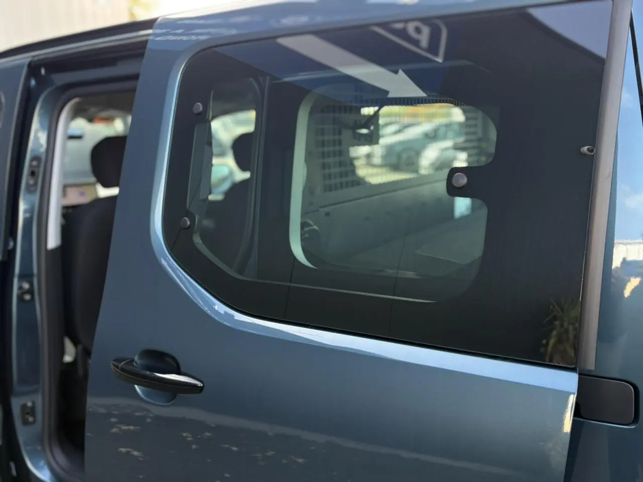 Porte latérale coulissante droite bleu métallisé du Citroën Berlingo Multispace 2025, vue rapprochée avec intérieur partiellement visible.