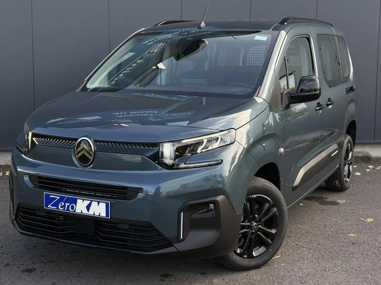 Citroën Berlingo Multispace bleu métallisé en 3/4 avant droit avec jantes alliage noires et barres de toit.