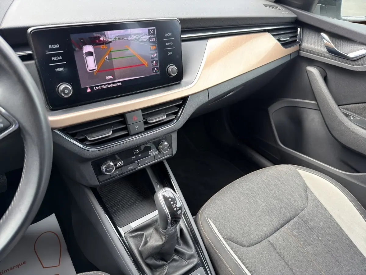 Vue rapprochée du combiné d'instruments du Skoda Kamiq 2023, affichant autonomie et compteurs analogiques.