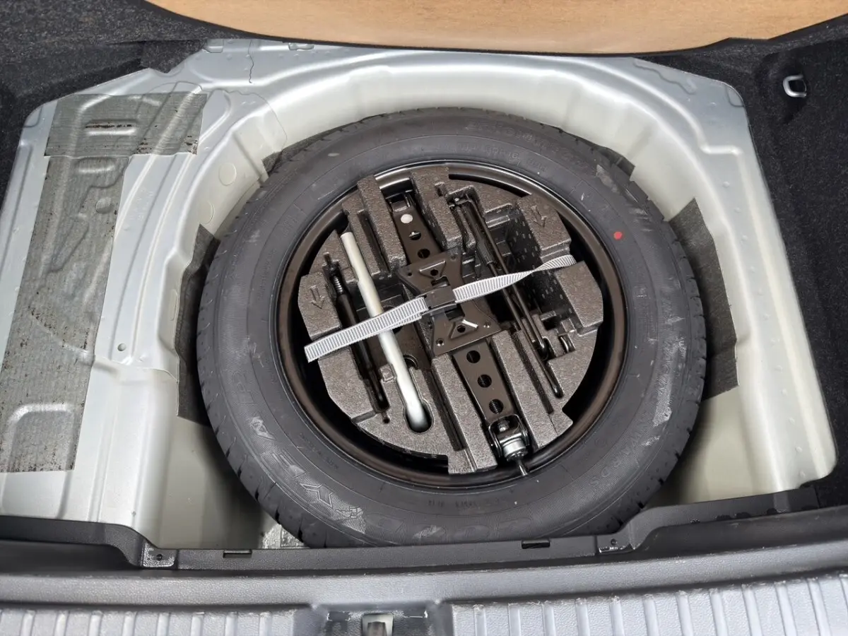 Coffre ouvert vu de l'arrière d'un Skoda Kamiq gris clair 2023 avec intérieur de coffre en tissu gris.
