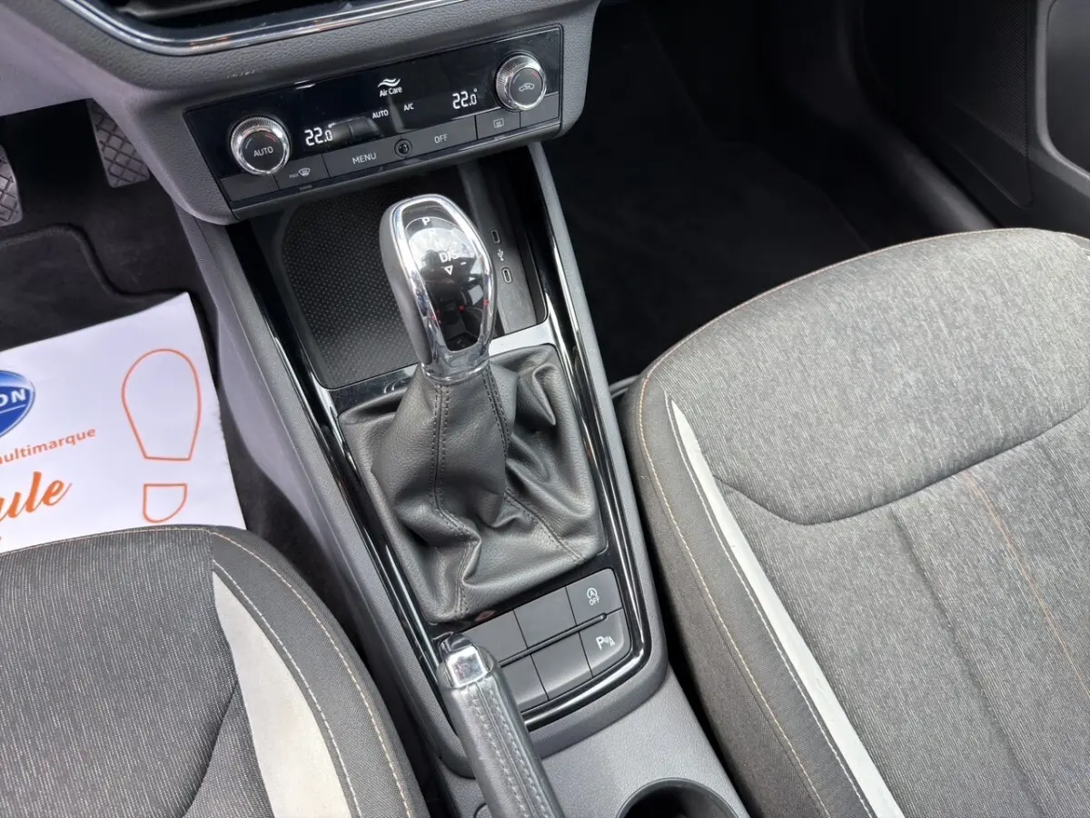 Vue rapprochée de l’écran tactile central et de la console de climatisation du Skoda Kamiq 2023, intérieur noir avec insert bois clair.