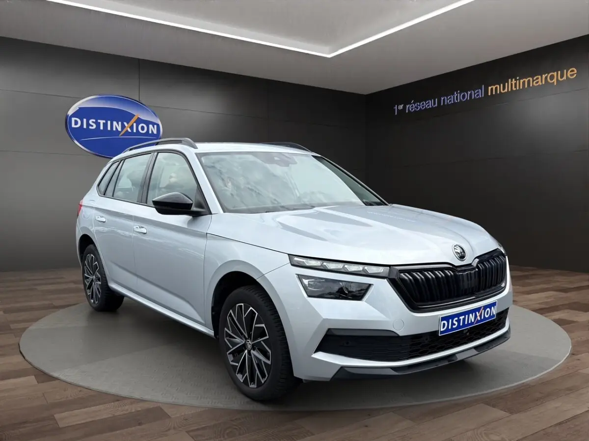 Vue latérale droite du Skoda Kamiq gris clair 2023 avec jantes bi-ton et rétroviseurs rabattables électriquement.