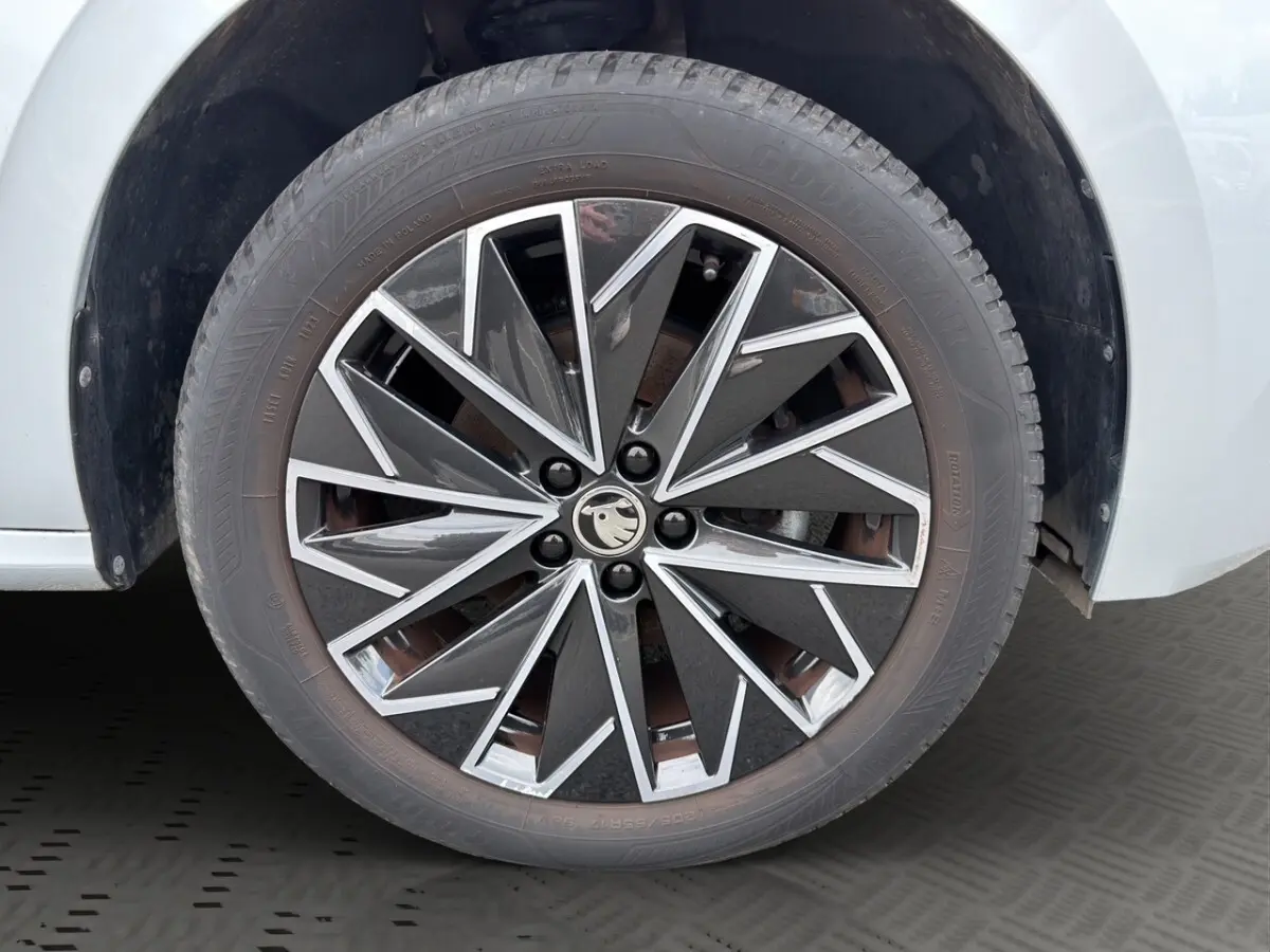 Vue avant d'un Skoda Kamiq gris clair 2023 avec calandre noire et logo distinctif au centre.