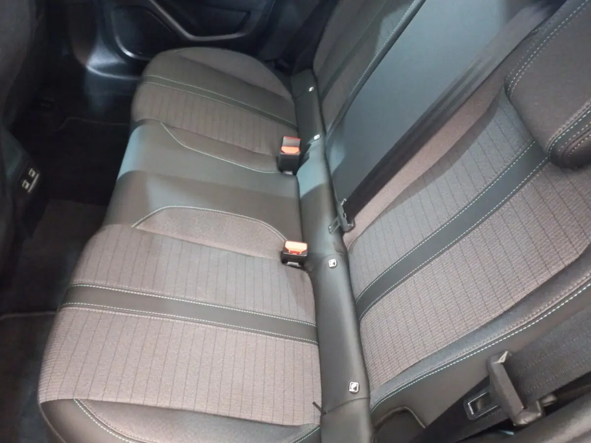 Vue plongeante sur la banquette arrière gris foncé de la Peugeot 208 PureTech 100 Allure Pack avec ceintures et ISOFIX visibles.