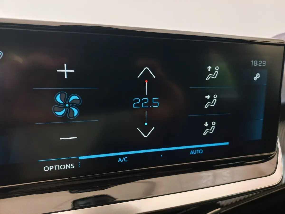 Écran tactile de la climatisation affichant 22,5°C dans l'habitacle d'une Peugeot 208 noire de 2022.