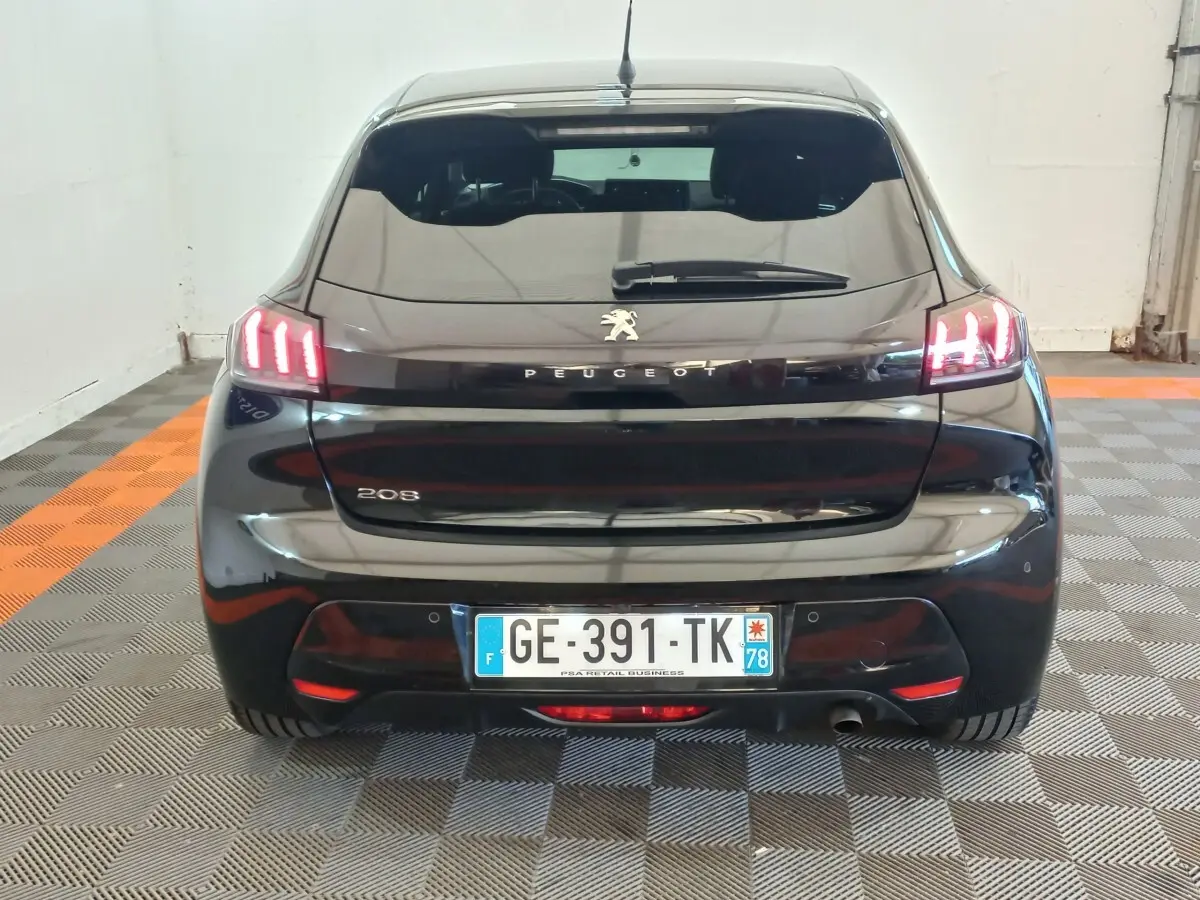 Vue arrière d’une Peugeot 208 noire 2022 avec feux arrière LED allumés et plaque d’immatriculation française.