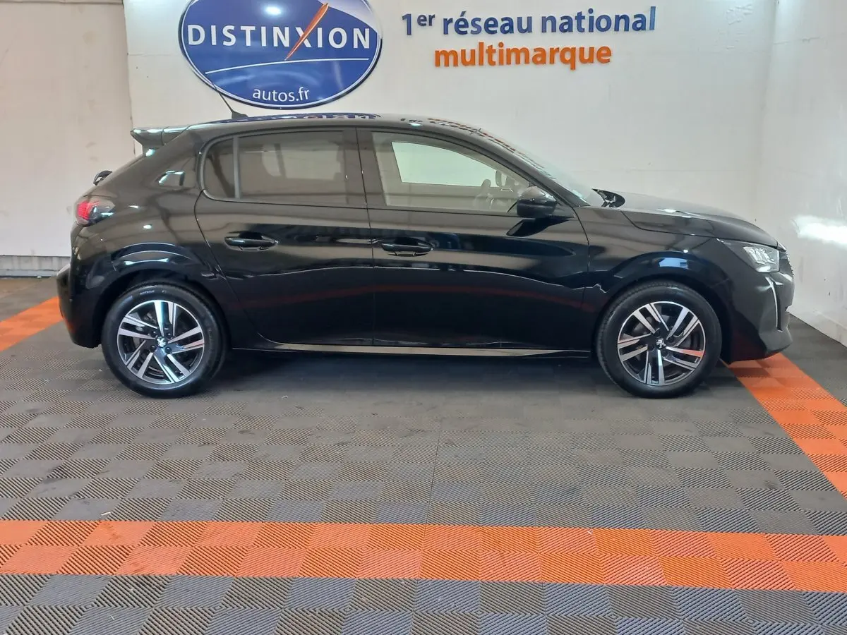 Peugeot 208 noire vue de profil côté gauche, avec jantes alliage et feux arrière LED visibles.