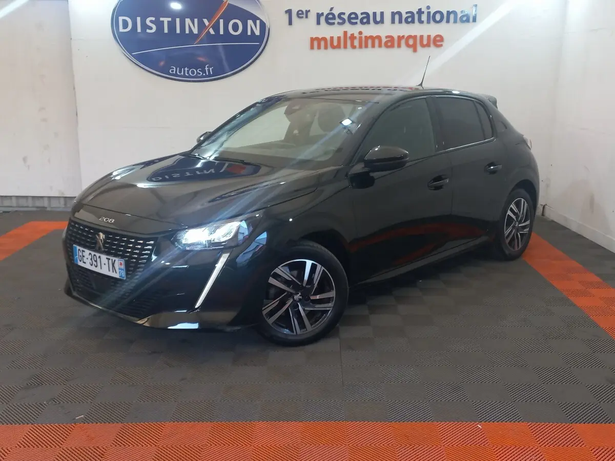 Peugeot 208 noire vue en 3/4 avant droit, avec phares LED allumés et jantes alliage distinctives.