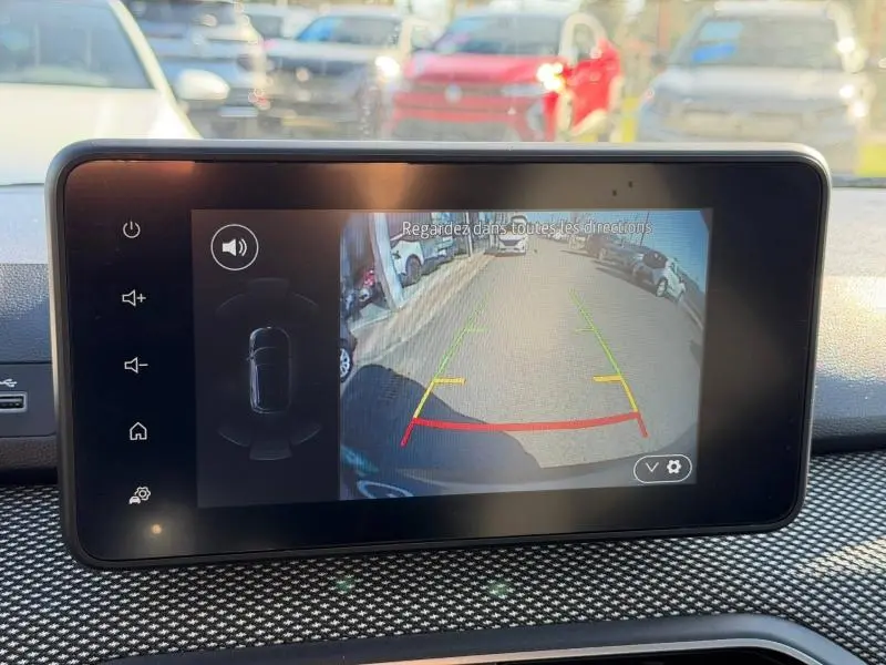 Écran de caméra de recul du Dacia Jogger 2025 montrant la vue arrière sur une route avec voitures garées.