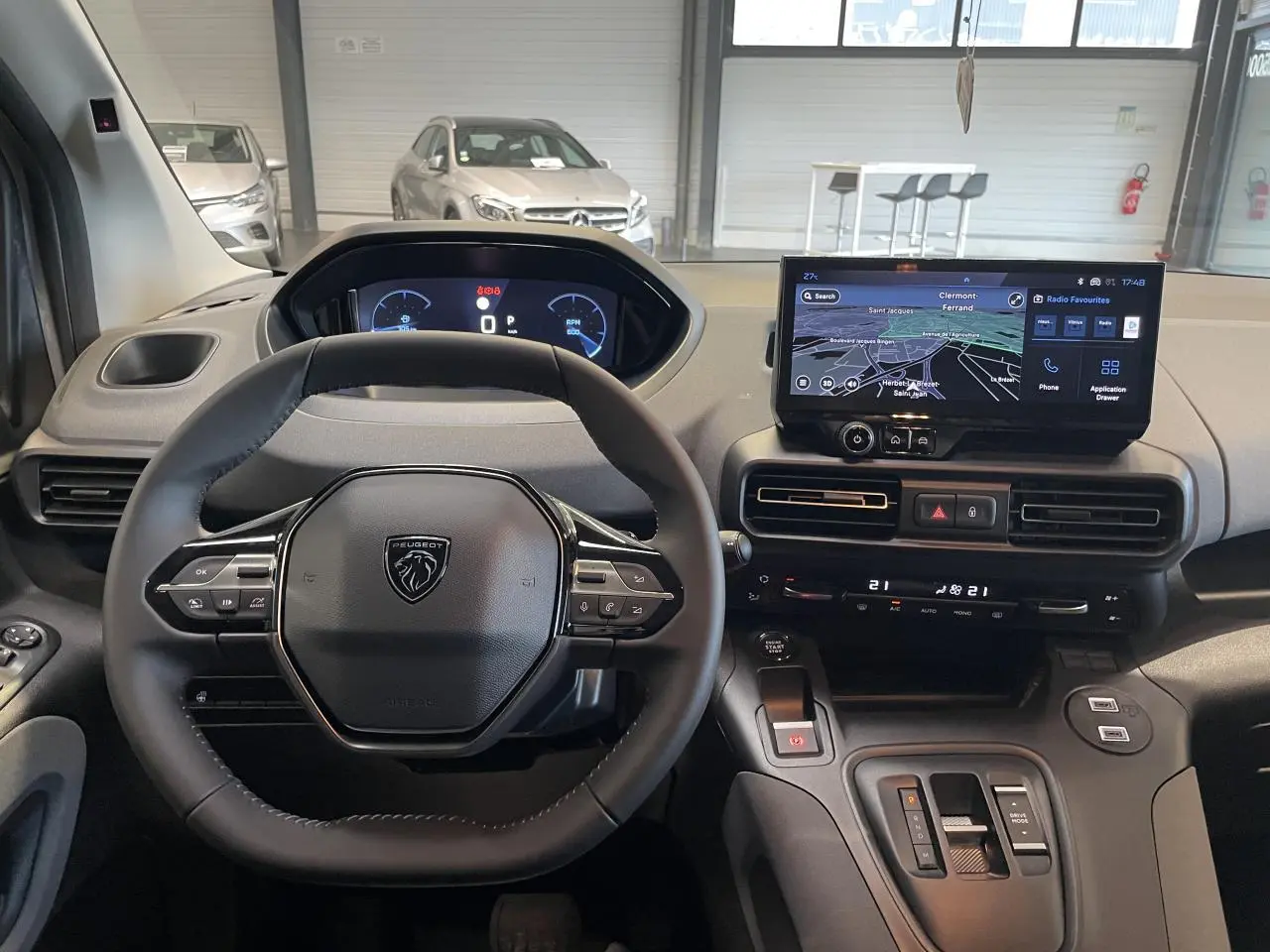 Vue intérieure du tableau de bord du Peugeot Rifter gris Artense, avec volant multifonction et écran tactile GPS.