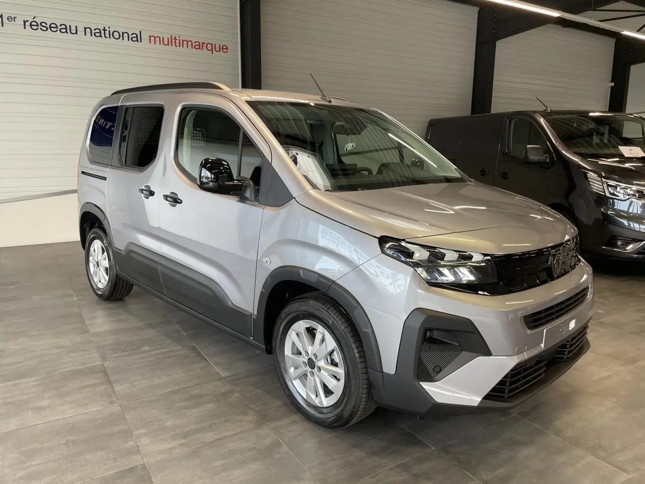 Peugeot Rifter gris Artense en 3/4 avant droit, avec coques de rétroviseurs noires vernies et jantes tôles 16 pouces.