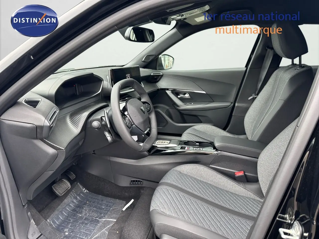 Intérieur avant droit du Peugeot 2008 noir métal 2025, sièges tissu gris et tableau de bord moderne avec écran central.
