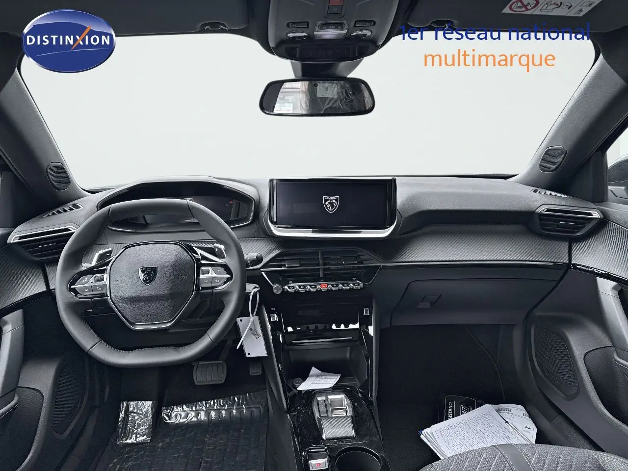 Vue intérieure avant du Peugeot 2008 Hybrid noir métal, tableau de bord moderne avec écran central et volant compact.