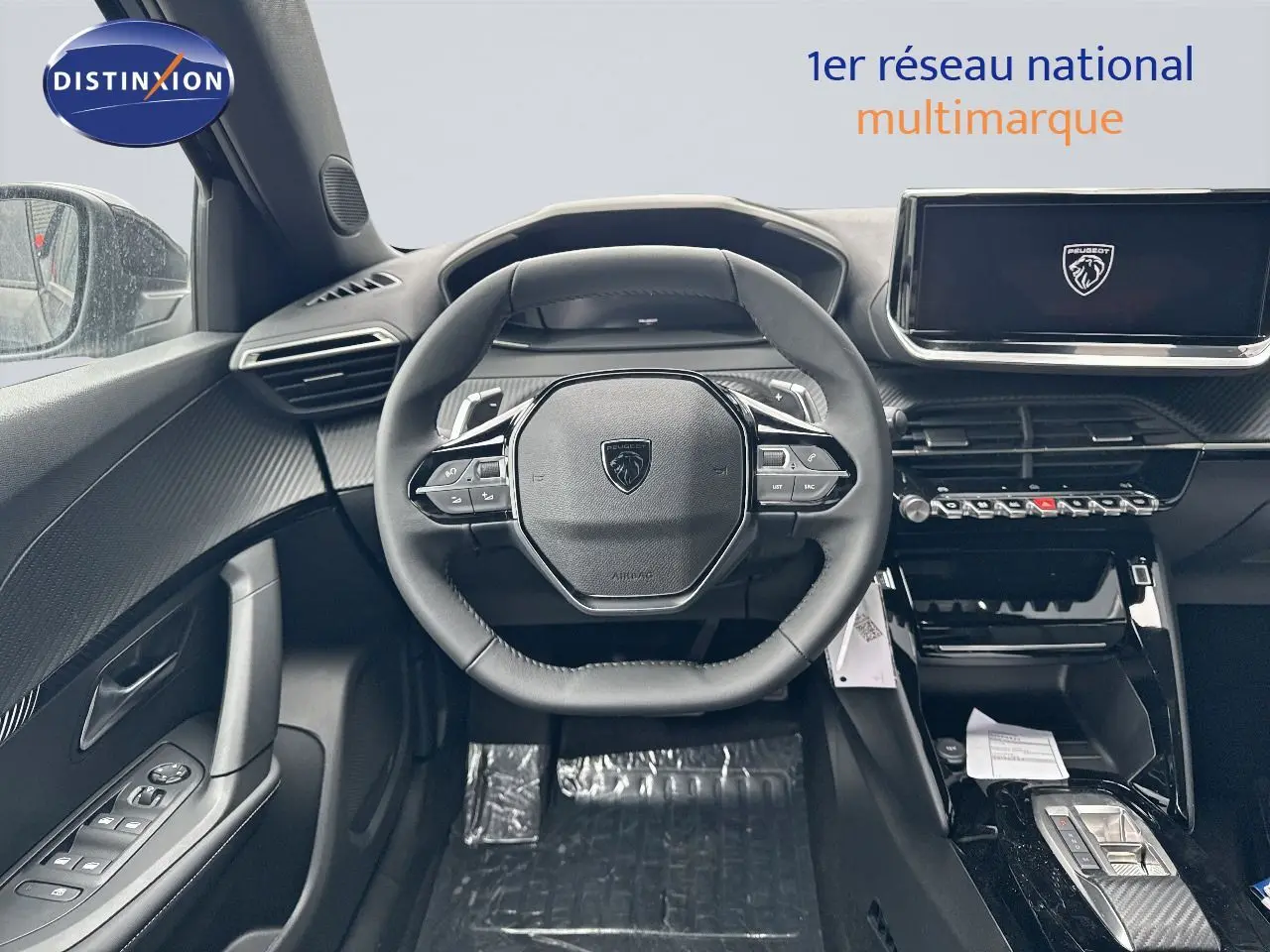 Intérieur noir du Peugeot 2008 Hybrid 136ch, vue frontale du volant compact et tableau de bord numérique moderne.