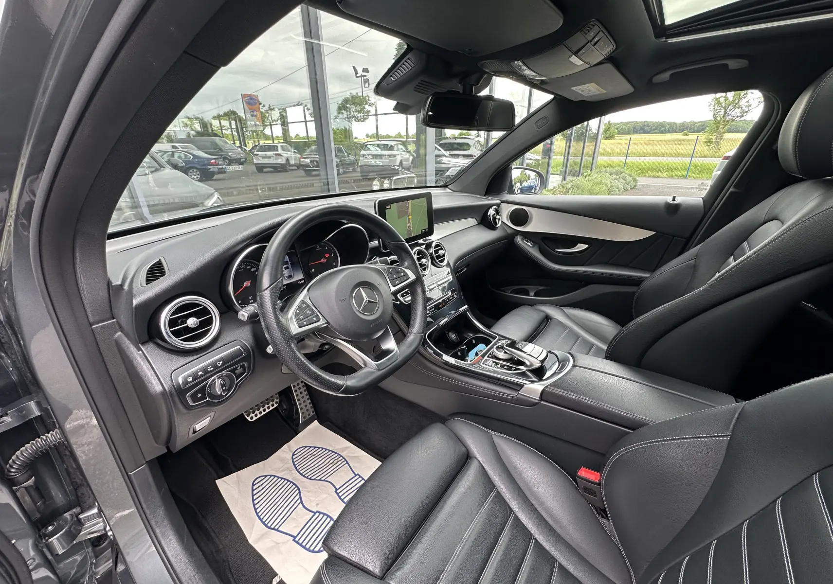 Intérieur noir du Mercedes GLC Coupé 250 D Fascination 4MATIC vu côté conducteur, avec tableau de bord moderne et écran central.