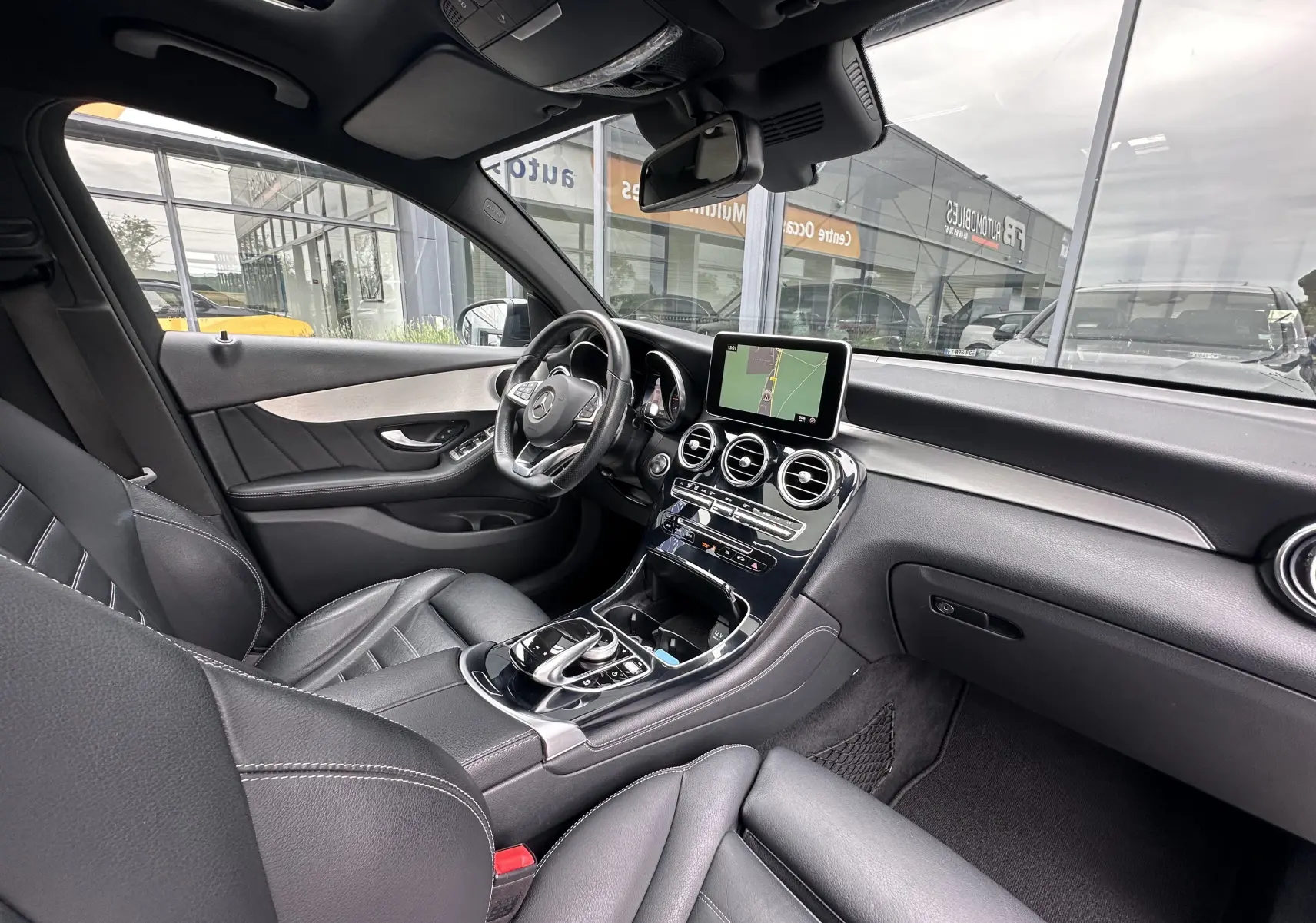Intérieur du Mercedes GLC Coupé 250 D Fascination 4MATIC 2018, vue côté conducteur, cuir noir et écran central tactile.