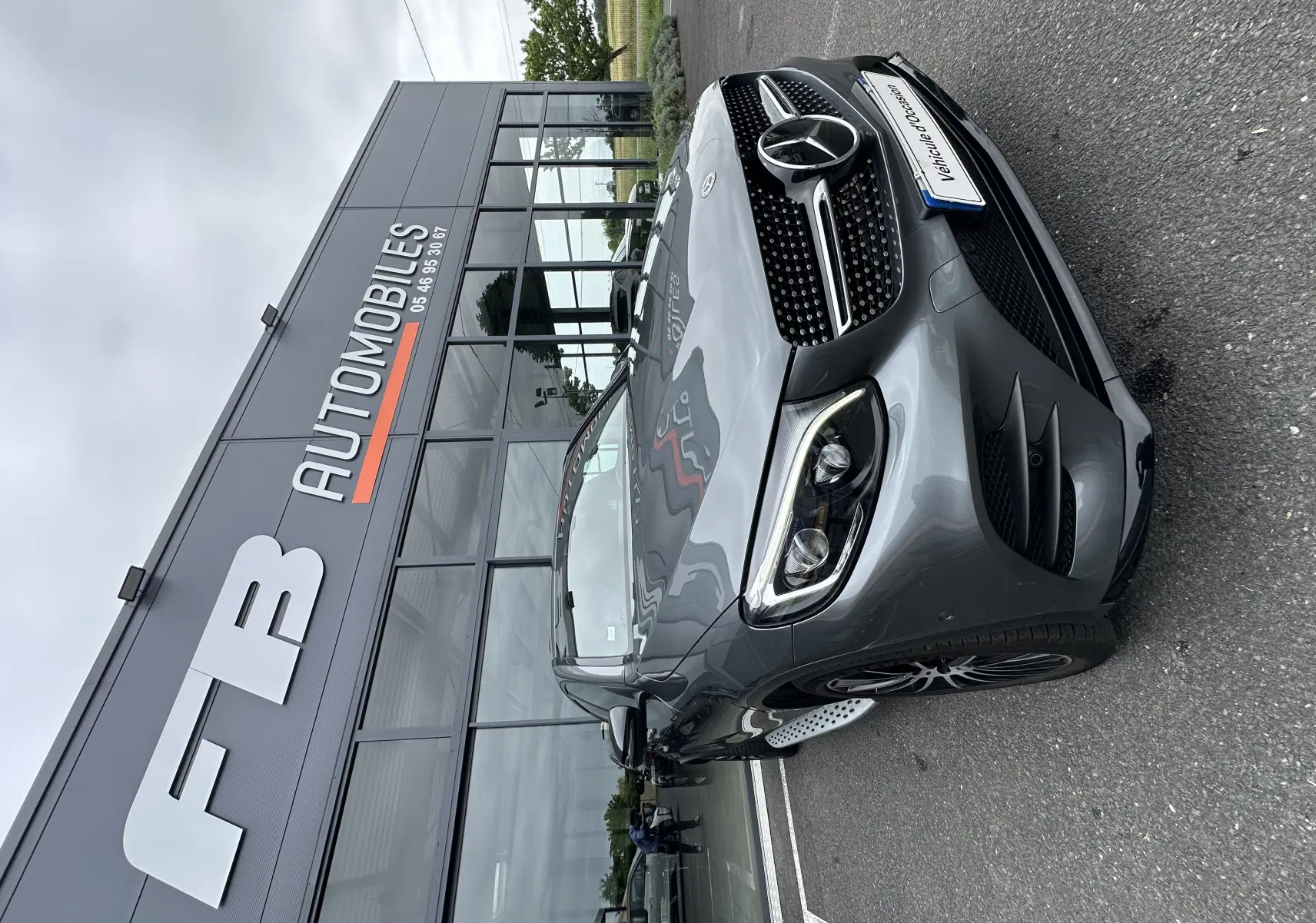 Mercedes GLC Coupé 250 D Fascination gris foncé vu en 3/4 avant droit devant un showroom automobile.