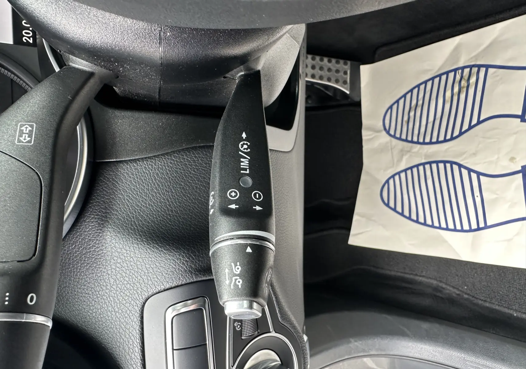 Gros plan sur la commande de régulateur de vitesse dans l'habitacle noir d'un Mercedes GLC Coupé gris foncé 2018.