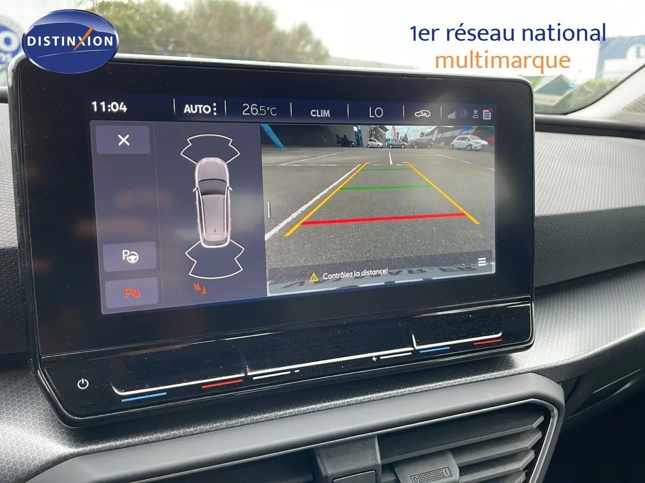 Écran central de la SEAT LEON ST 2023 montrant la caméra de recul avec guidage de trajectoire en gris urbain.