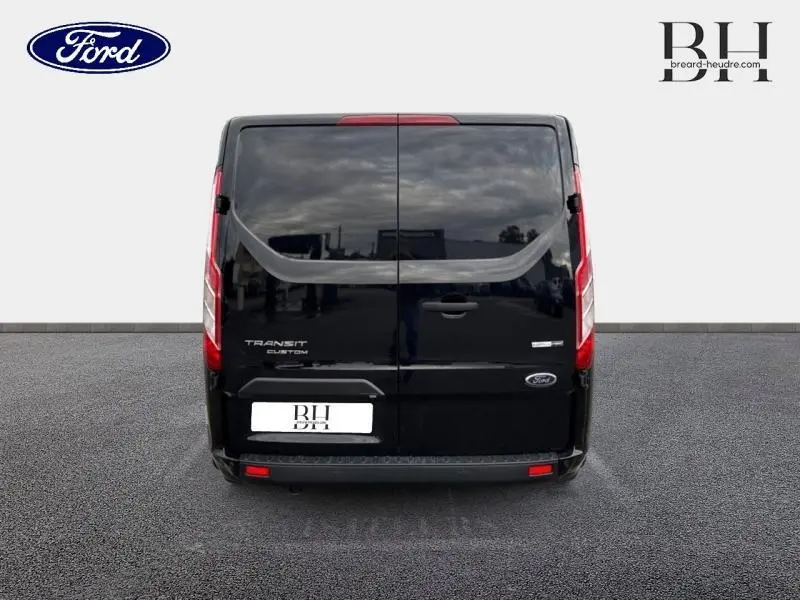 Vue arrière du Ford Transit Custom noir Agate métallisé avec portes battantes et feux arrière verticaux.