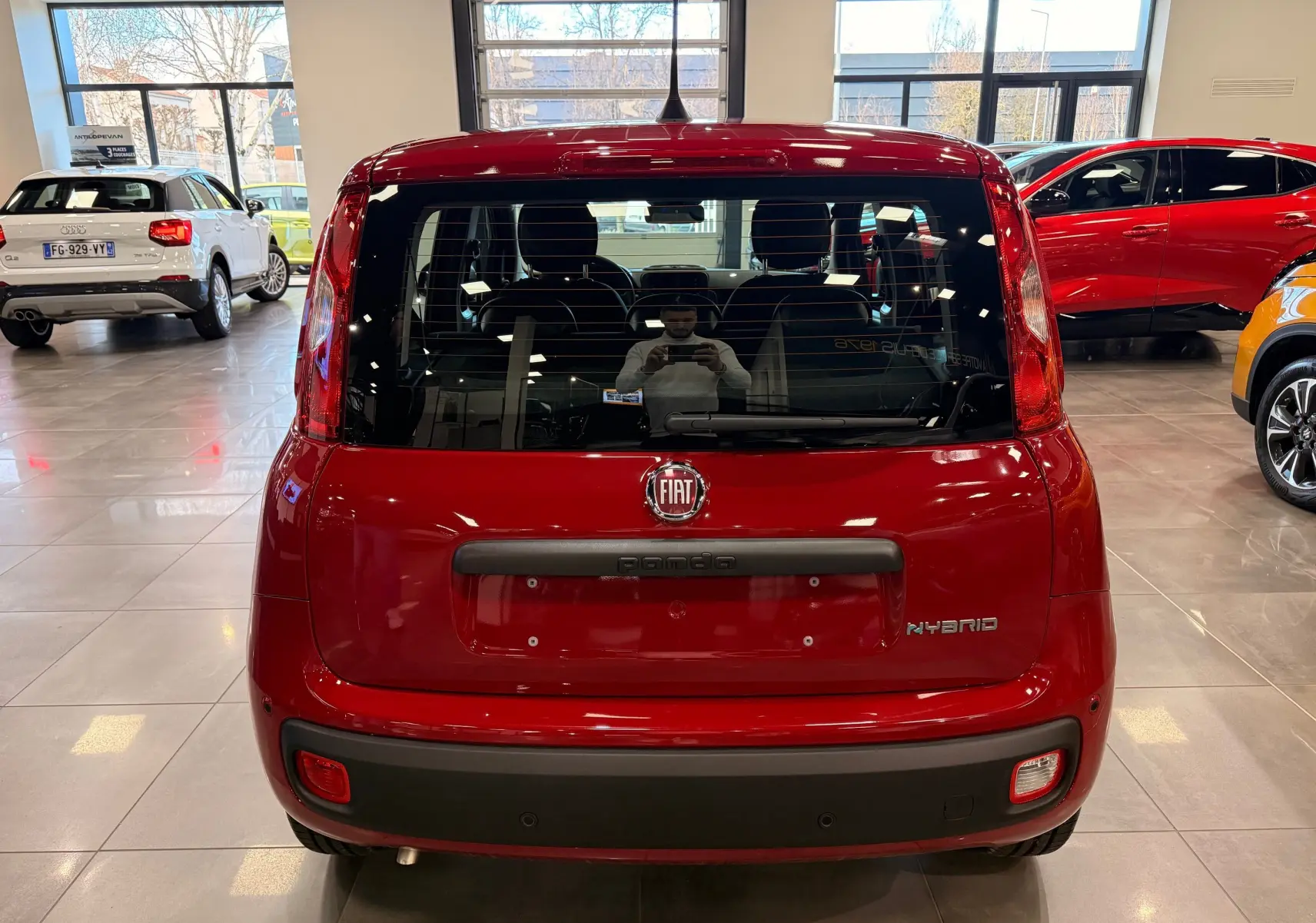 Vue arrière d'une FIAT Panda 1.0 70 CH Hybrid City rouge Amore, avec logo FIAT et badge Hybrid visible.