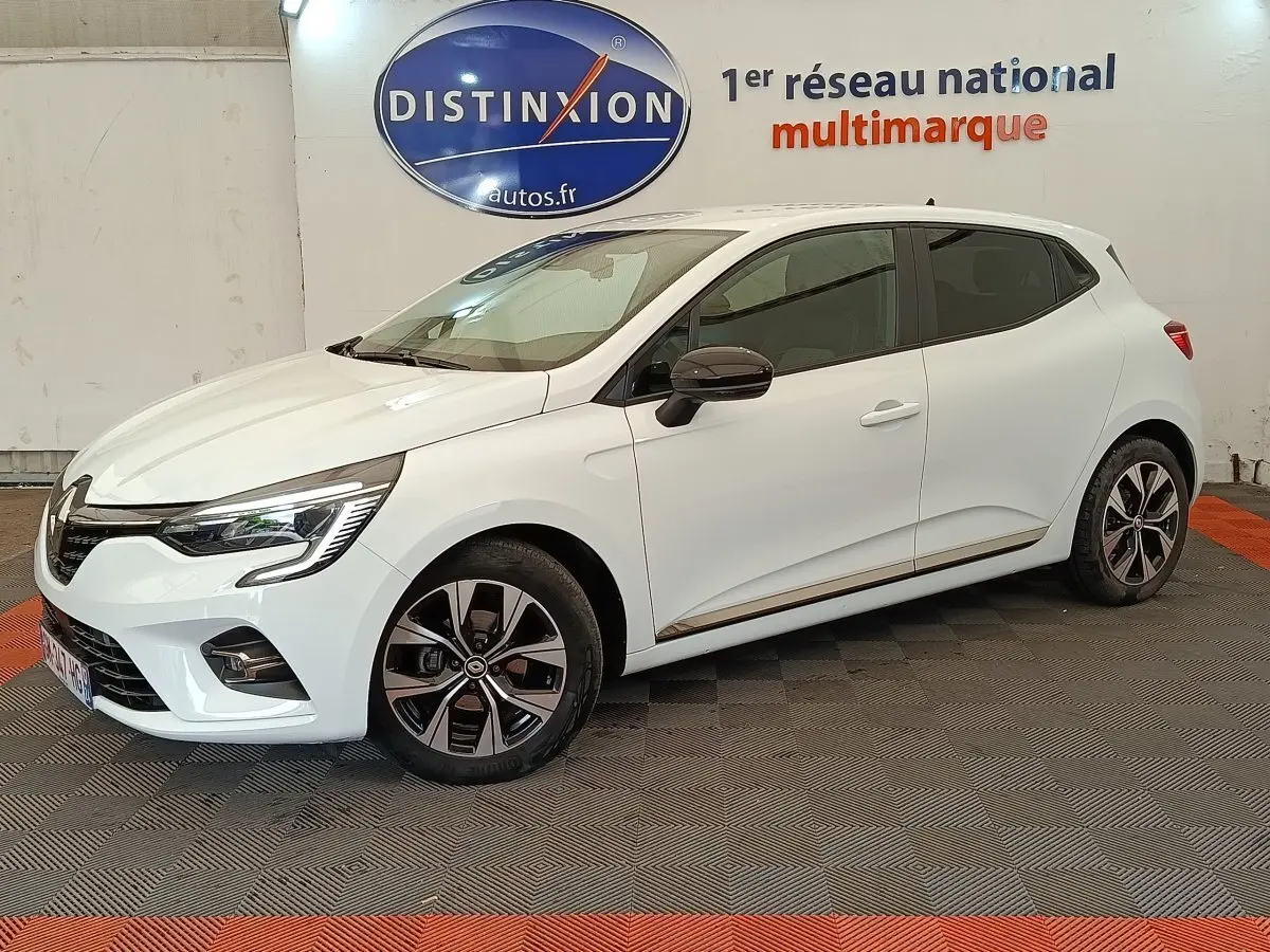 Renault Clio Evolution TCe 100 GPL blanc vue de profil droit en intérieur avec jantes alliage et feux LED allumés.