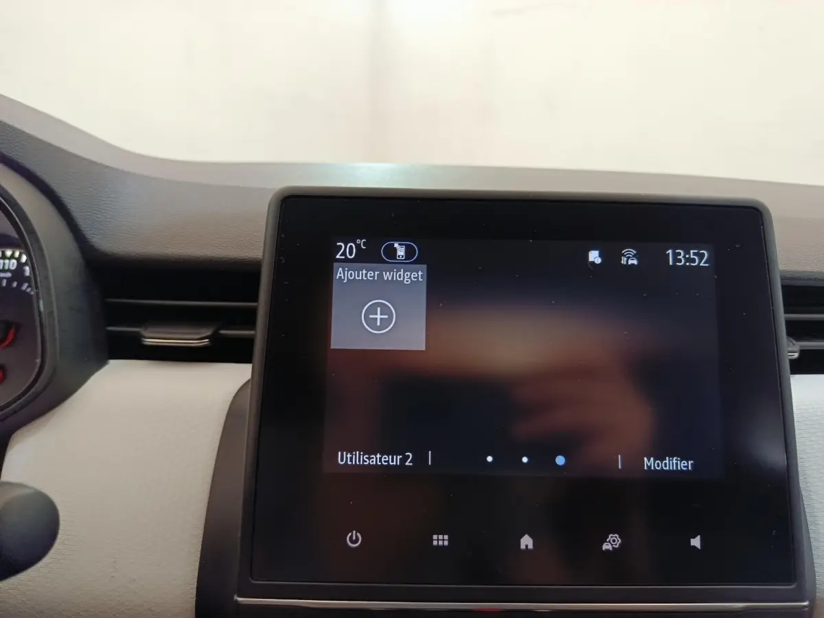 Écran tactile central de la Renault Clio blanc 2023 affichant le menu principal avec options utilisateur.