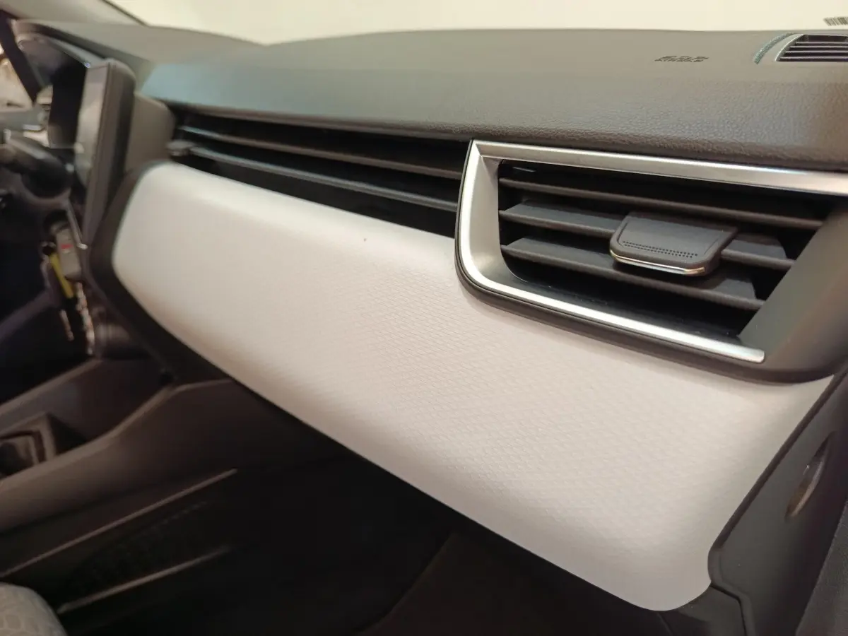 Détail de la planche de bord blanche et noire de la Renault Clio Evolution TCe 100 GPL 2023, côté passager.